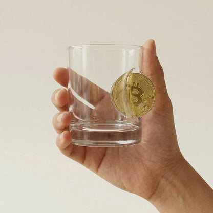 Bitcoin Whiskyglas mit eingearbeiteter Münze – handgemachtes Krypto Geschenk als Lifestyle-Foto in der Hand gehalten – handgemachtes Glas von MELTGlas